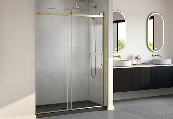 A luxurious bathroom featuring brushed gold accents in sliding shower doors, framed mirrors & fixtures