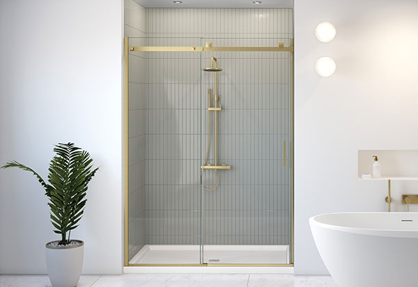 A sliding shower door in brushed gold finish in a white bathroom