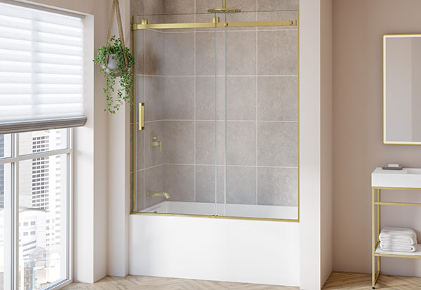 Brushed gold tub enclosure, vanity & LED mirror in a bathroom with pink walls