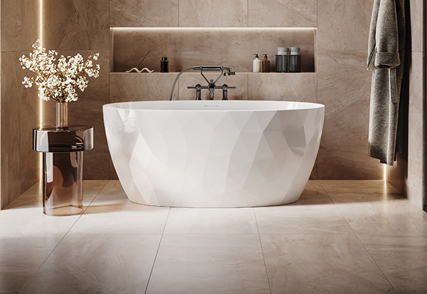 La baignoire autoportante en acrylique Tonnetz Petite de Fleurco est installée dans une salle de bain luxueuse. Elle présente une texture 3D en forme de losange/triangle. Les murs de la salle de bain sont recouverts de carreaux de pierre beige foncé de très grande taille, avec une bande DEL pour un éclairage d'ambiance spectaculaire.