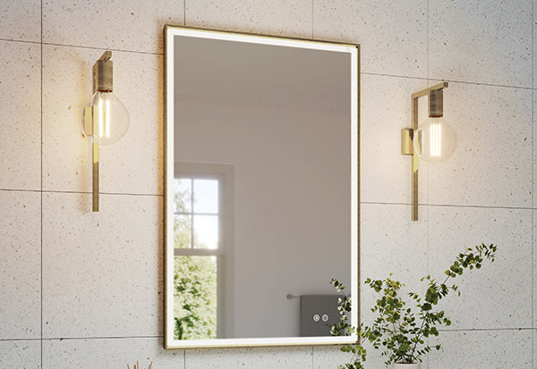 A modern bathroom featuring a Rectangular LED Mirror with a brushed gold frame decorating a floating countertop with exposed plumbing. 
