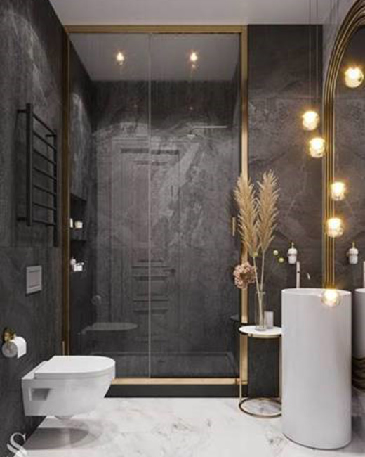 une salle de bains noire et moderne et élégante avec des accents et des touches d'or brossé ; une porte de douche en verre