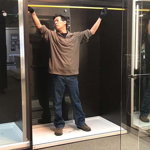 fleurco installer measuring the top opening of shower enclosure