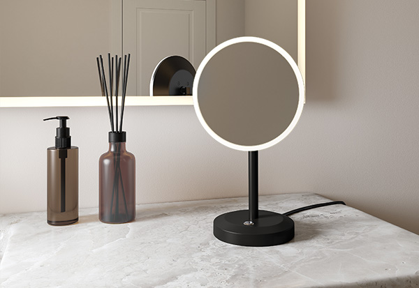 a cosmetic led mirror with a round shape & matte black finish standing on the counter.